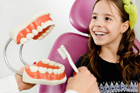 微笑的小女孩学习如何在牙齿下图片
