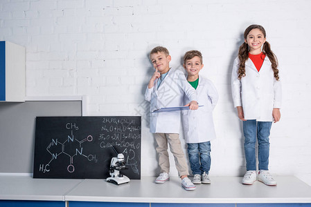 两个穿白大衣的小男孩女在化学实验室里笑图片