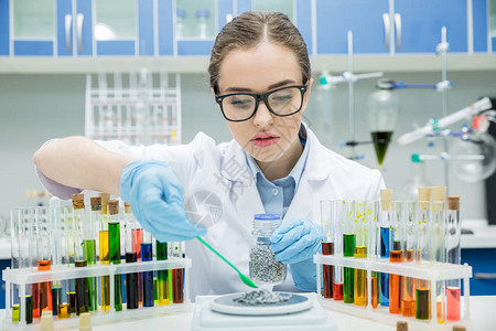 在化学实验室使用试剂的集中女科学家图片