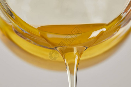 从玻璃罐中流出的甜蜂蜜的特写视图图片