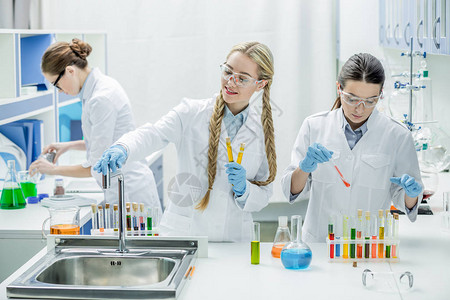 年轻女科学家与化学实验室试剂合作的图片
