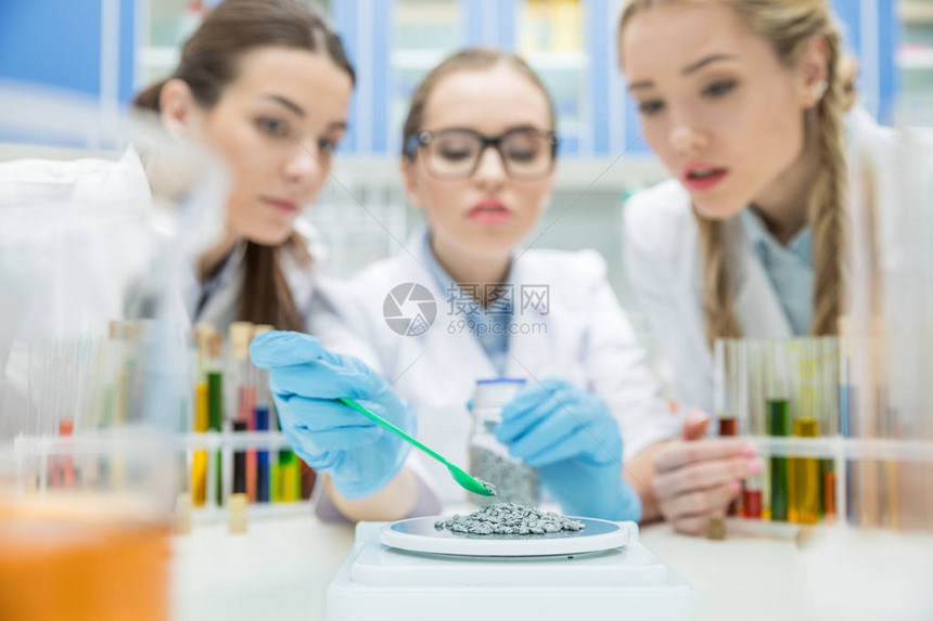 年轻女科学家与实验室化学试剂一起工作的图片