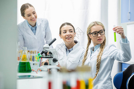 年轻女科学家在化学实验室内研究带有背景图片