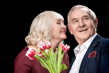 快乐的老年情侣与郁金香花束图片