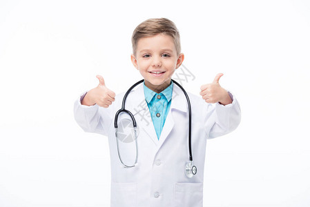 穿着医生服装微笑的小男孩手拇指在图片