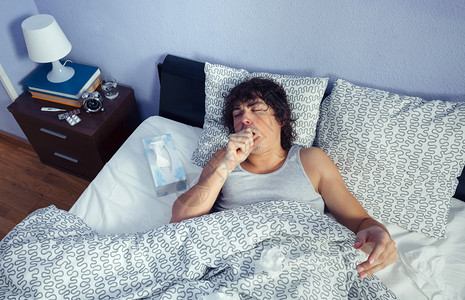 咳嗽躺在床上的年轻病人的肖像疾高清图片
