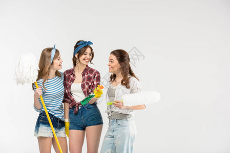 三名美丽的年轻美女拿着清洁用品在白边说图片