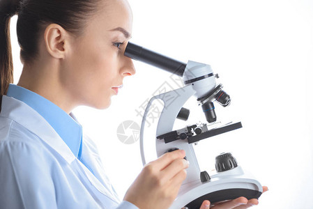 通过显微镜观察白色的集中女科学家背景图片