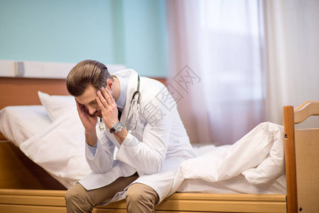 男医生坐在医院床上手抓着图片