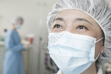 在手术室戴外科面具和外科帽的图片