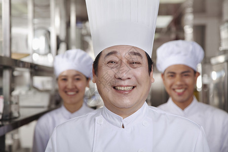 工业厨房的三位厨师背景图片