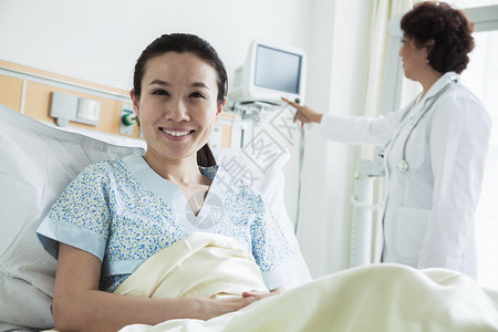 坐在医院病床上微笑的女病人背景中使用医图片