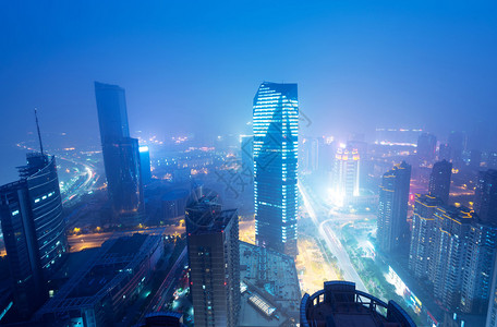 南昌鸟瞰图前景中正在建设的摩天大楼雾阴天和污染外滩背景图片