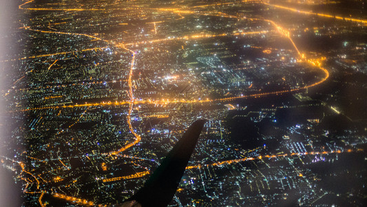 城市上空的飞机翼被照亮图片