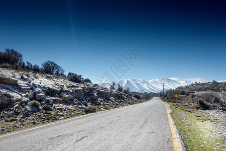 长的道路背景是白雪皑的山脉图片