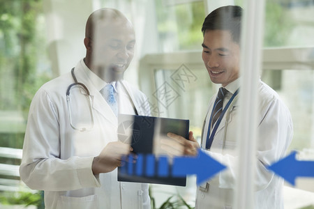 两名医生在玻璃门另一侧就医疗记录进行咨背景图片