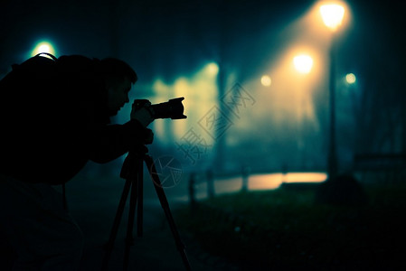 摄影师在有雾的公园夜间拍图片