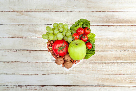 心形板盘上新鲜有机蔬菜和水果的顶部视图图片