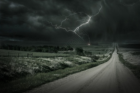 风暴乡间石灰路和暴风雨前方远距离闪电博尔特图片