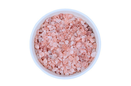 白色背景上带粉红盐的隔离陶瓷碗图片