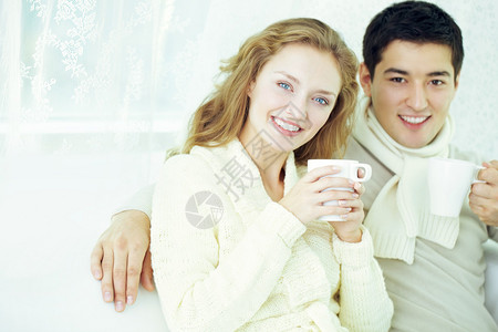 快乐的情侣喝茶看着相机图片