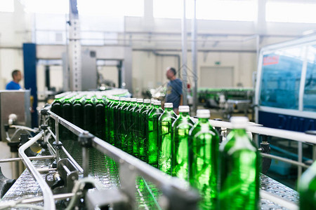 水厂用于将纯净矿泉水加工和装瓶成绿色玻璃瓶的水装瓶生产线图片