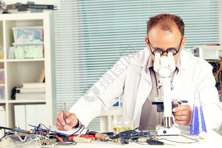 实验室化验技术员通过显微镜检查并在实验图片
