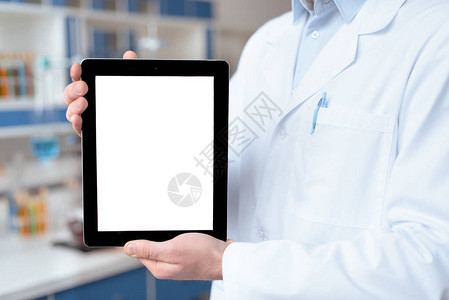 实验室大衣中显示数字平板电脑空白屏幕的医生近图片
