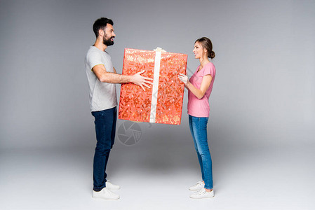年轻夫妇与大红礼盒站在一起图片