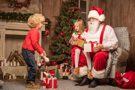 圣诞老人和幸福的孩子坐在一起看图片