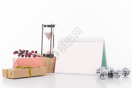 近视白色的空白日历沙钟松果和包装礼物图片