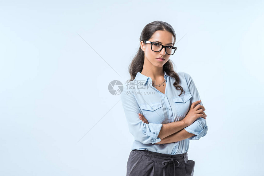 满怀自信的女商人画像手跨过双臂看着蓝色图片
