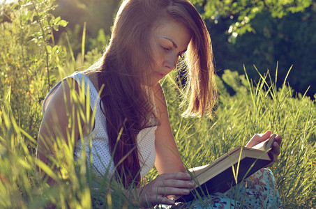 俄罗斯草地上看书的漂亮女孩背景图片