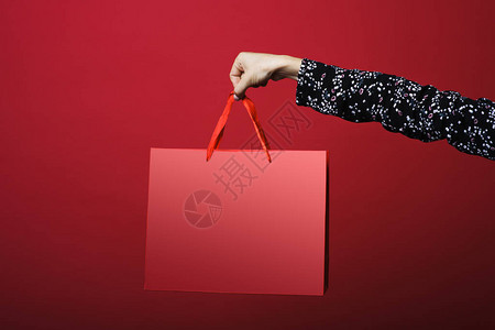 妇女手持纸袋用红色背景的图片