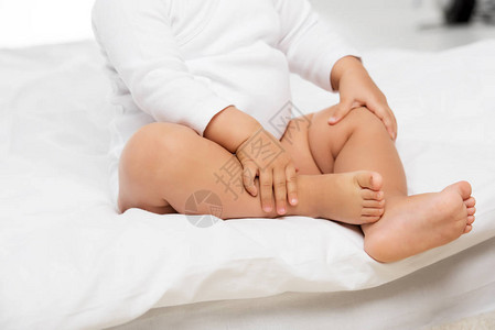 婴儿穿着紧身衣裤坐在床上的短片图片