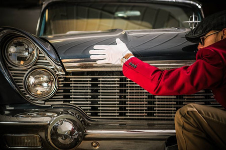 美国古典汽车评估专业工人在寻找车辆的损坏物图片