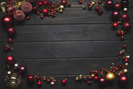 木制表面上排列的闪亮多彩圣诞玩具的顶部视图图片