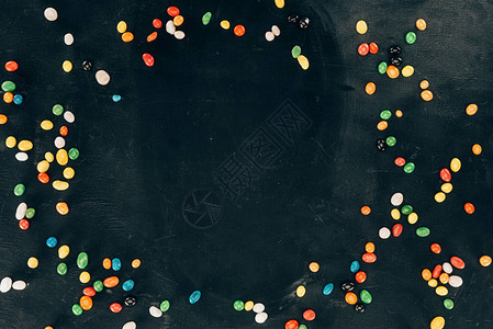 黑色桌面上彩色糖果的背景图片