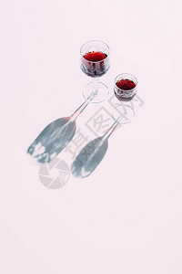 粉红色桌面上两杯红葡萄背景图片