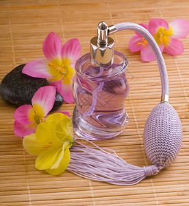 木垫上的紫花和玻璃香水瓶图片