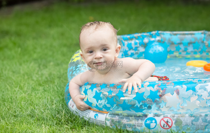 可爱小男孩的肖像在花园的充气游泳图片