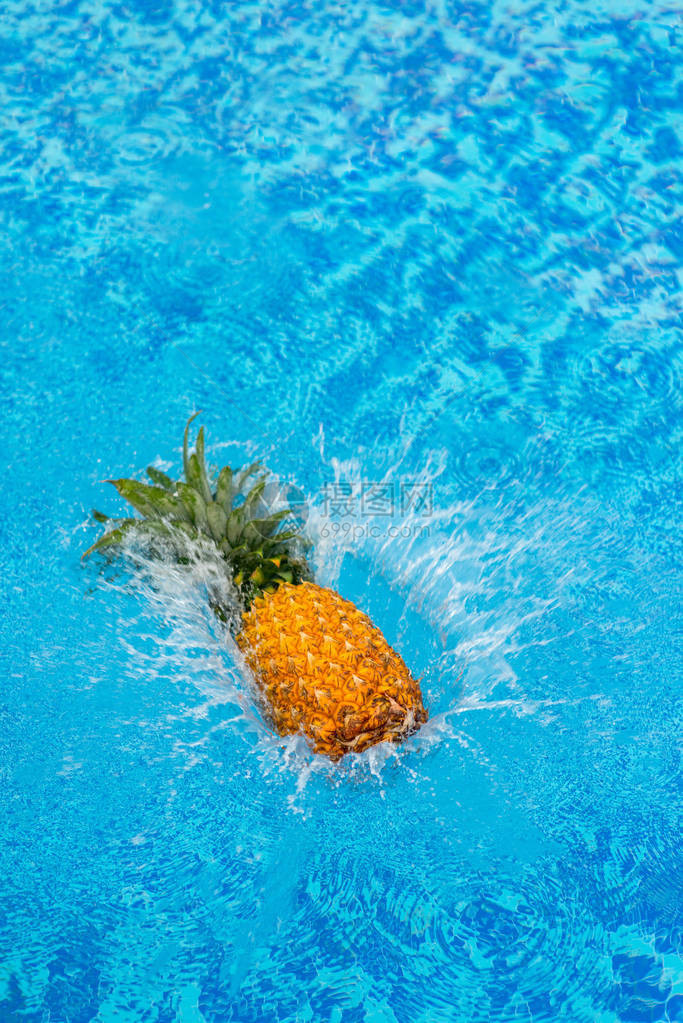 在游泳池水中坠落菠萝图片