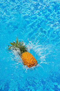 在游泳池水中坠落菠萝图片
