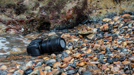 单反相机和远摄镜头在石滩旅行和测试时被水海浪弄湿图片