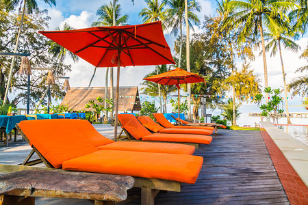 酒店和度假村游泳池周围的雨伞和椅子图片