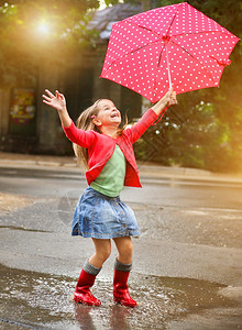 身着红雨靴的Polka圆点雨伞的背景图片