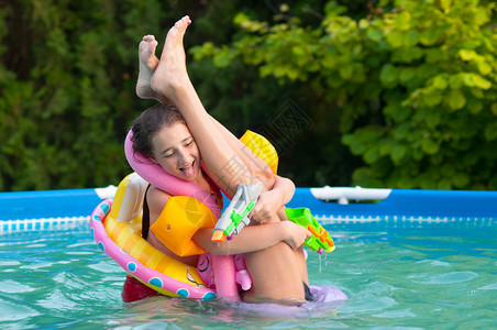 两个十几岁的女孩在家里游泳池玩得开心带着童年玩图片