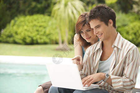 一对夫妇用笔记本电脑游泳图片