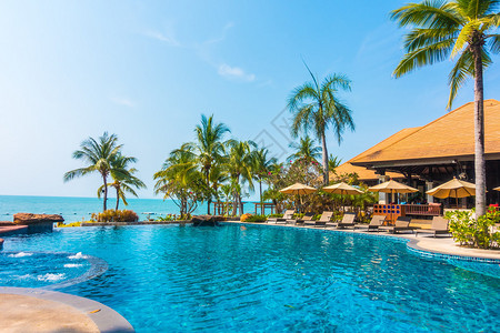 在酒店泳池度假胜地有棕榈树和海背景的游泳池图片