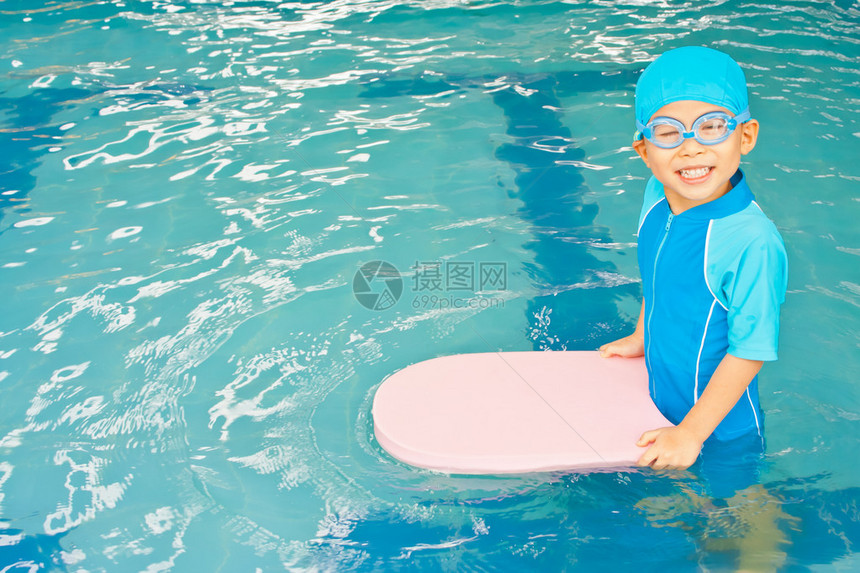 游泳衣的亚裔男孩在水池图片